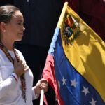 108653018-files-venezuelan-opposition-leader-maria-corina-machado-holds-a-venezuelan-national-flag-a.jpeg