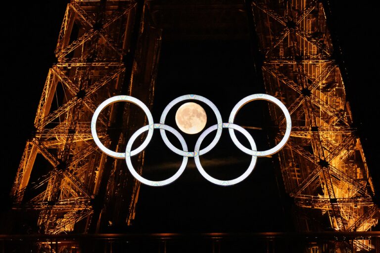 109334693-topshot-afp-pictures-of-the-year-2024-the-moon-rises-behind-the-olympic-rings-dis.jpg