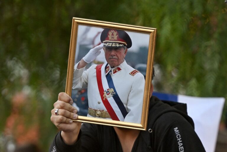 113312172-a-man-shows-a-portrait-of-the-late-chilean-dictator-1973-1990-augusto-pinochet-following-t.jpeg