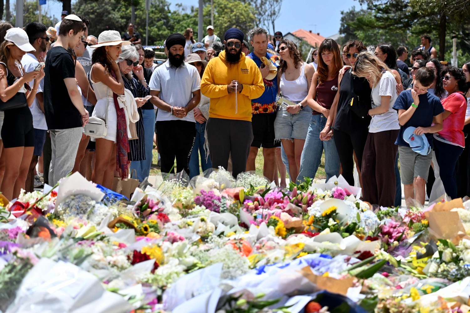 113313635-mourners-gather-by-floral-tributes-at-the-bondi-pavillion-in-memory-of-the-victims-of.jpg