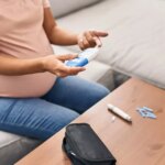 229630270-young-latin-woman-pregnant-measuring-glucose-home-scaled.jpg