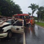 The driver gets stuck in the wreckage after the car collides with the parked bus
