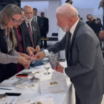 Lola distributes candy at a meeting in Planalto to apologize for being late