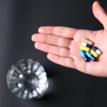 colorful-medical-pills-hand-person-glass-water.jpg