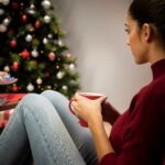 mulher-olhando-um-copo-com-um-fundo-de-natal.jpg