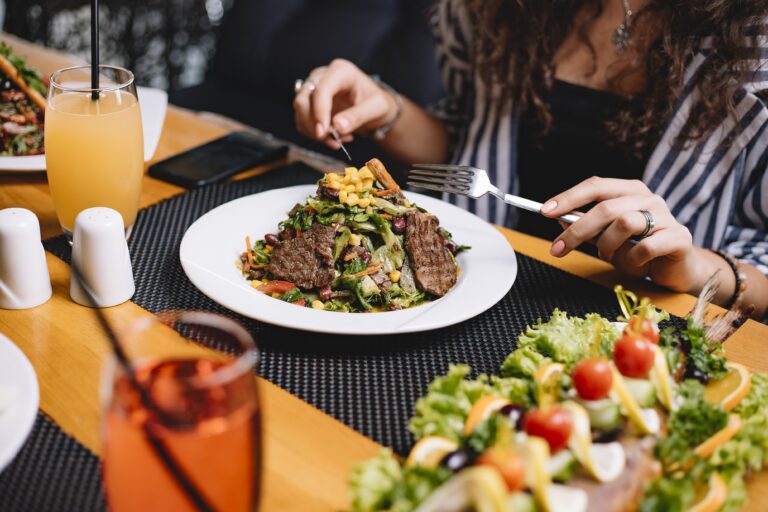 side-view-woman-eating-beef-meat-salad-with-vegetables-corns.jpg