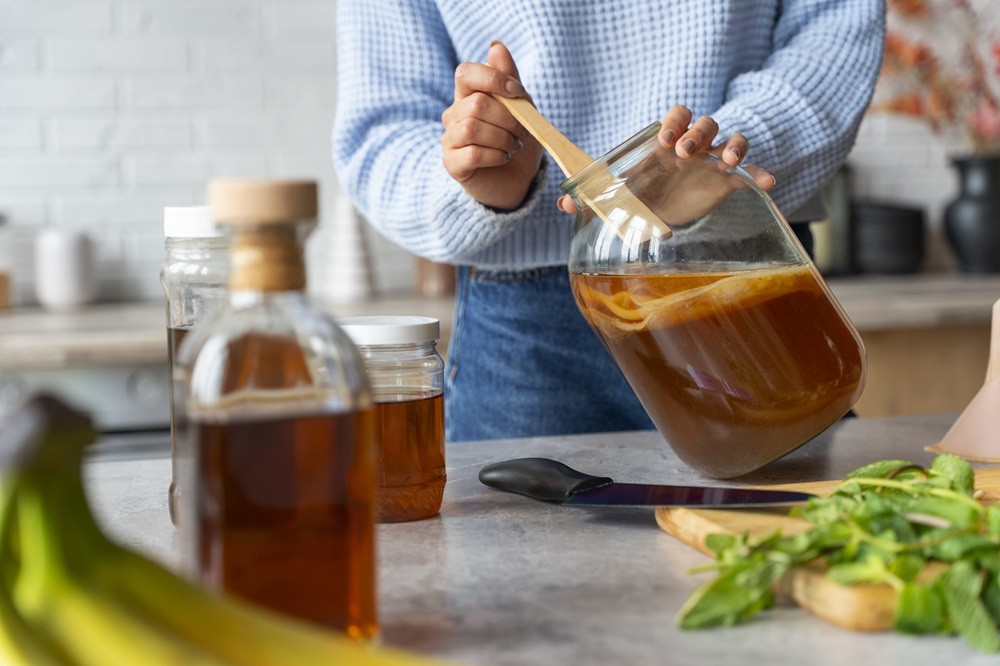 woman-preparing-kombucha-front-view.jpg