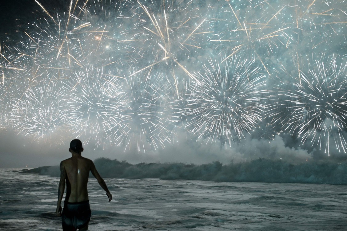 113414520-a-man-celebrates-as-he-watches-the-traditional-new-years-fireworks-from-the-water-at-copa.jpeg