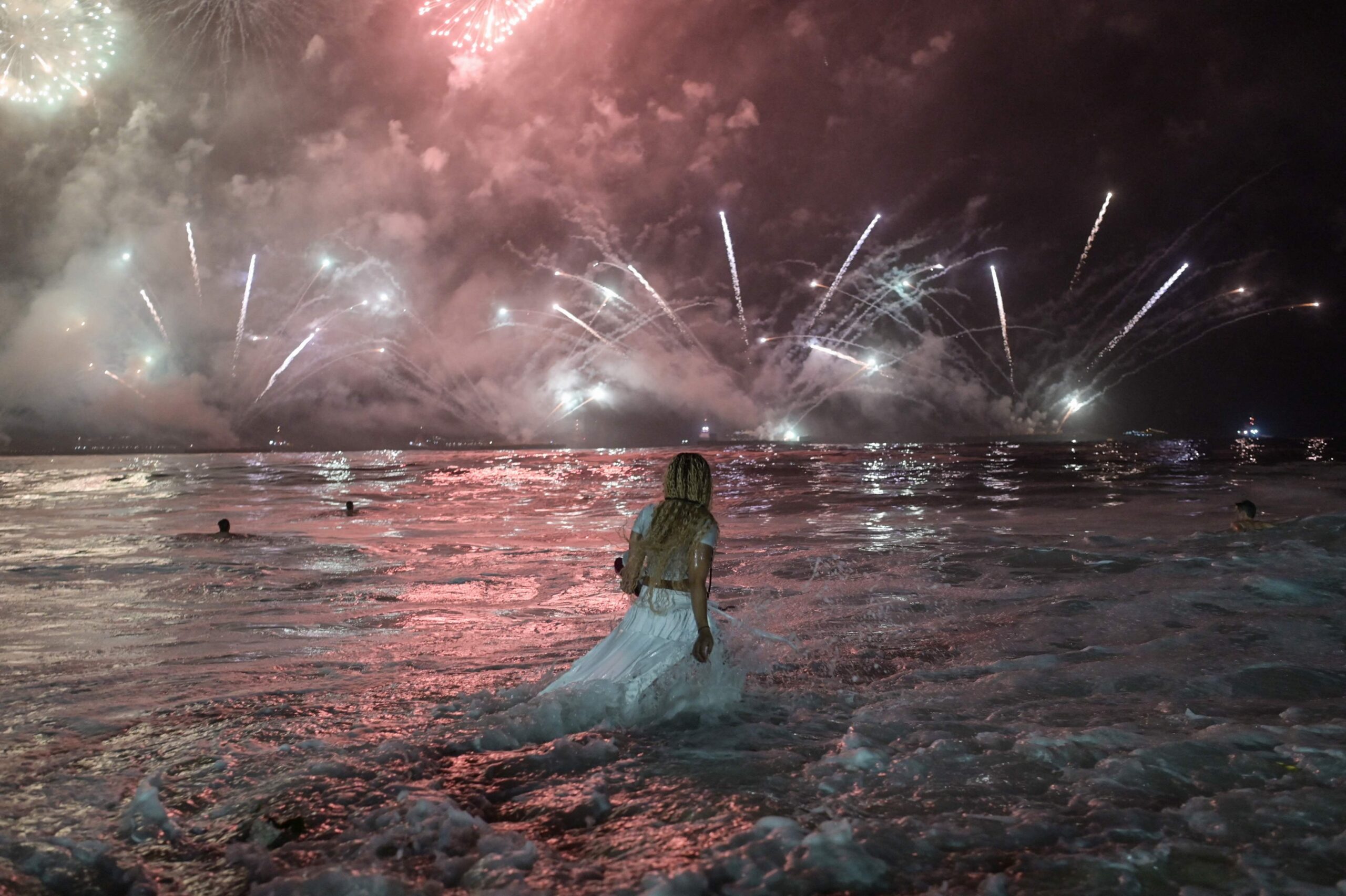 113414734-a-woman-watches-the-traditional-new-years-fireworks-from-the-water-at-copacabana-beach-in.jpeg